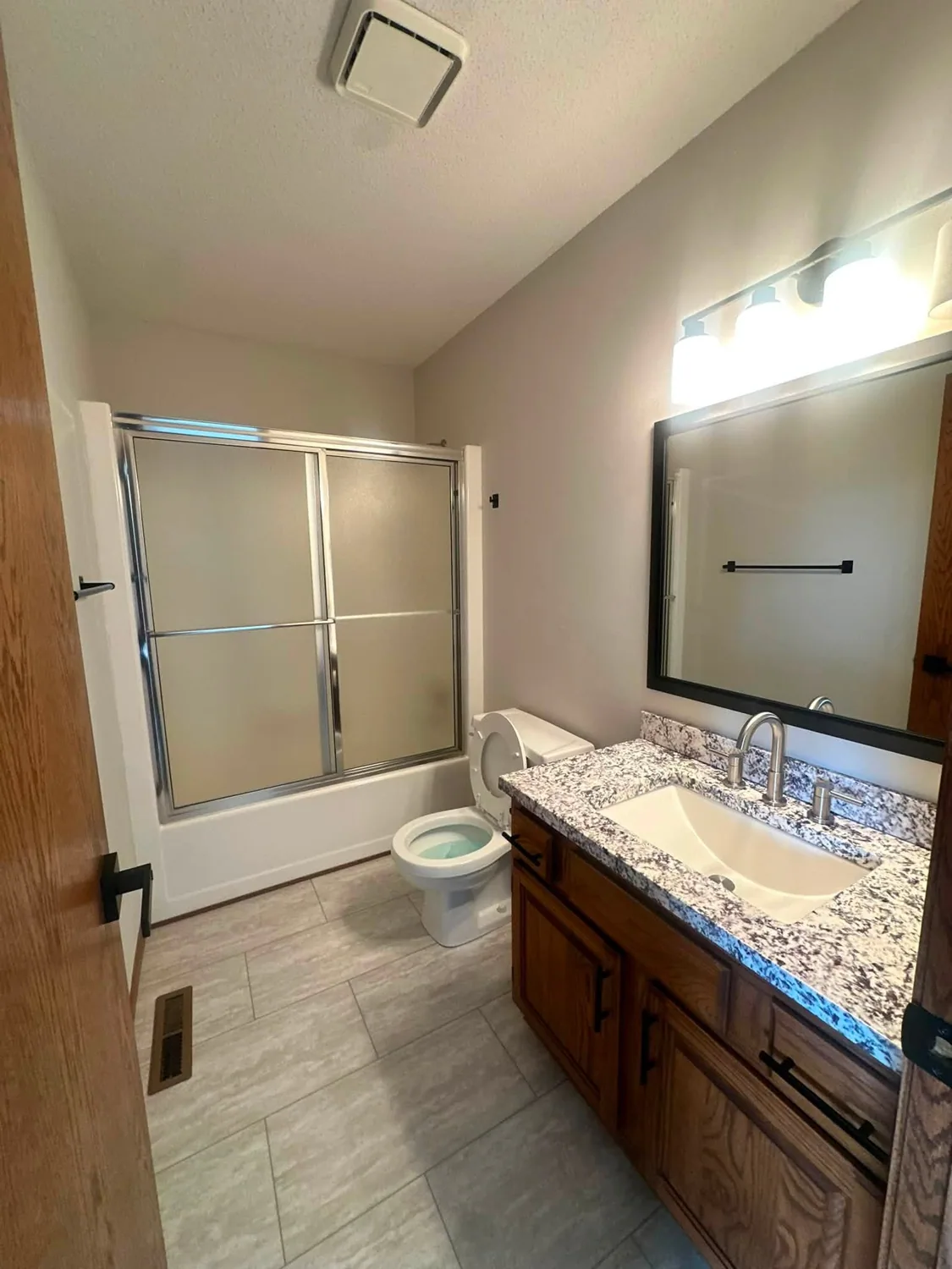 Bathroom with clean tiled shower and counter